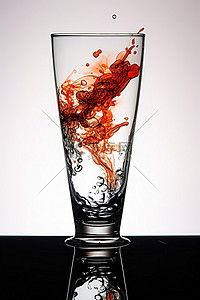 装满水的玻璃杯背景图片_白色背景前的桌子上放着一个装满油漆和墨水的玻璃杯
