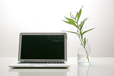 空玻璃瓶背景图片_一台笔记本电脑和桌上一个装满水的空花瓶