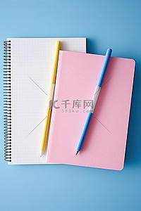 粉色的笔背景图片_两个笔记本，里面有粉色和蓝色的笔