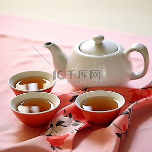 两杯红茶和一个粉红色布上的茶壶