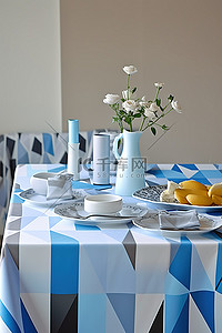 有水的桌子背景图片_一张铺有蓝色和白色桌布的桌子