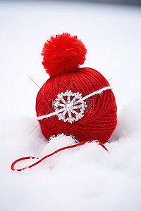 红色羊毛针织球和坐在雪中的蝴蝶结