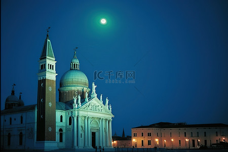 在月亮背景图片_教堂和教堂塔楼在夜间亮起灯光