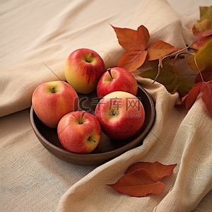 苹果放在布桌上，旁边有叶子