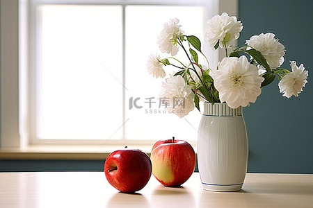 一个绿色花瓶，里面有鲜花和苹果