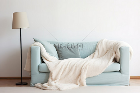 毯子背景图片_白色沙发，配有台灯和毛茸茸的休闲毯
