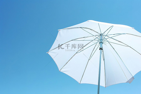 雨伞背景图片_蓝天映衬着一把白色的雨伞