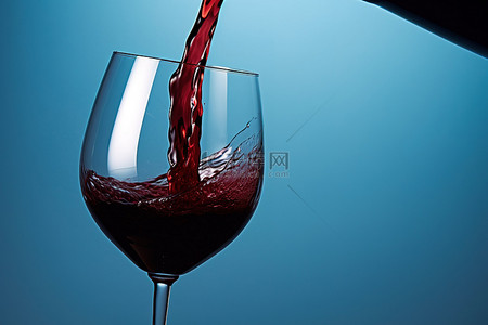 蓝色背景中倒入玻璃杯的葡萄酒