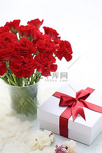母亲节礼盒背景图片_白色的桌子上摆着红色康乃馨，上面有白色礼盒