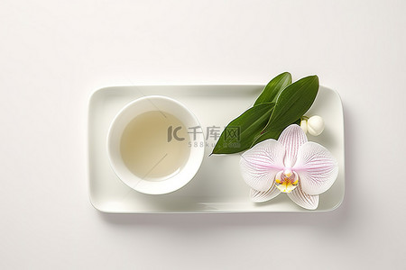 碗里的热绿茶和白兰花