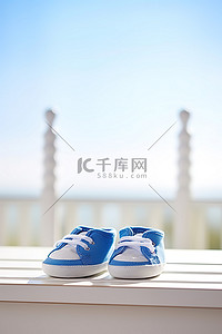 婴儿鞋背景图片_白色木凳上绣有蓝色袜子的蓝白色婴儿鞋