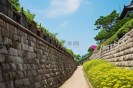 城堡城堡背景图片_一堵墙，有一条通往鲜花的小路