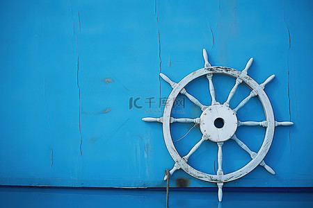 一艘船的轮子坐落在蓝色的墙上