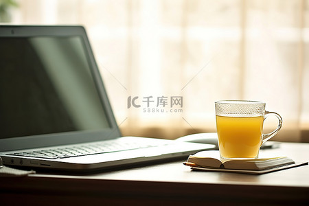 桌上办公用品背景图片_桌上有一台笔记本电脑，配有笔和杯子