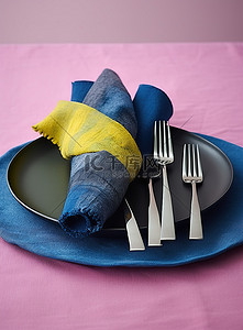 银器包装背景图片_蓝色和黄色的餐巾与银器一起摆放