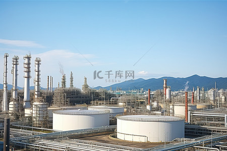 背景是一座山的城市里的一座大型炼油厂