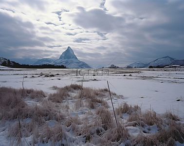 三座山峰背景图片_三座山峰和几座山附近被雪覆盖的田野