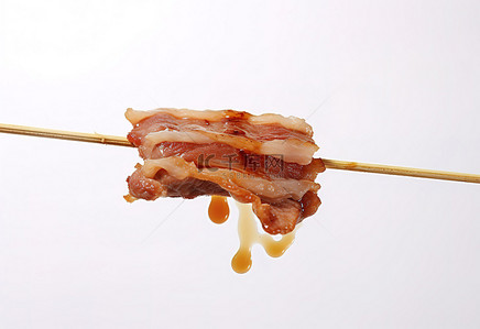 白色背景上筷子上挂着的一块切片食物