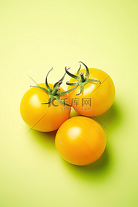 食品背景黄色背景图片_绿色背景中的三个黄色西红柿