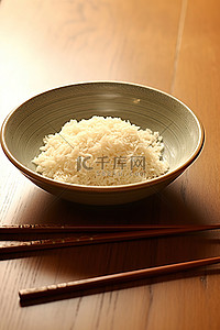 木桌上盘子里的米饭和筷子