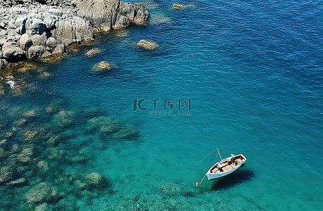 海洋和船背景图片_蓝色海洋中的一艘船和岩石
