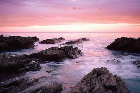 半岛背景背景图片_海洋有粉红色的天空，在岩石上形成紫色的天空