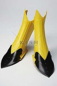 黄色和黑色的水肺潜水脚蹼坐在白色的表面上