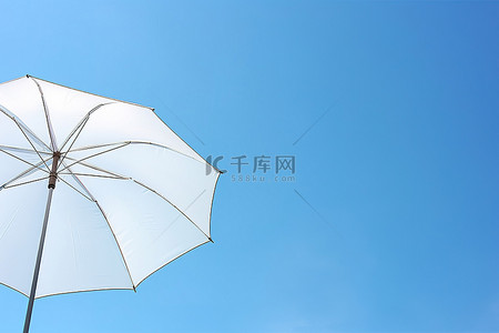 在蓝天中打开白色的雨伞