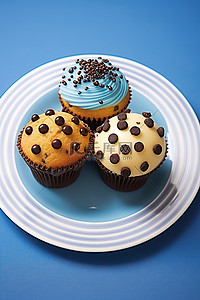 波尔卡背景图片_三个巧克力蛋糕纸杯蛋糕放在盘子上，上面有蓝色波尔卡