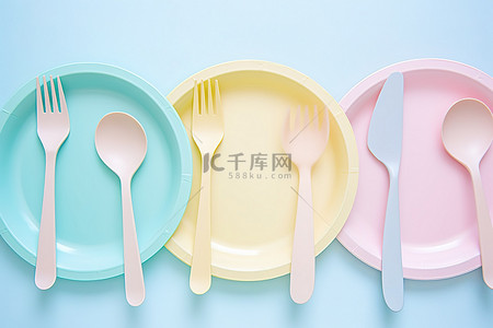 蓝色的盘子背景图片_五块盘子，配有蓝色和柔和颜色的勺子和叉子