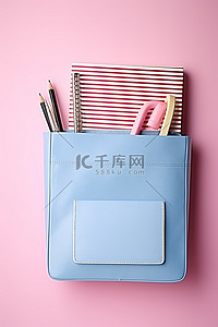 画展手提袋设计背景图片_笔记本铅笔和钢笔位于粉色手提袋的内袋中
