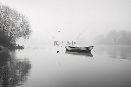 水里背景图片_水面上的一艘船，上面漂浮着雾气