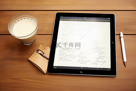 ipad苹果背景图片_木桌上的黑色桌面 ipad，配有苹果笔