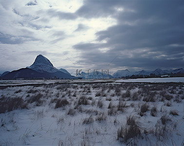 三座山峰背景图片_三座山峰和几座山附近被雪覆盖的田野