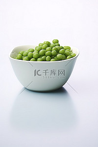 白色背景下碗里的绿豌豆