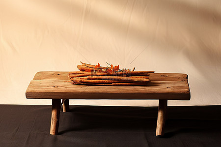 一张旧木桌，上面有橙色的棍子