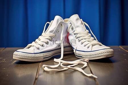 情侣白色背景图片_白色匡威鞋，用绳子将它们系在一起