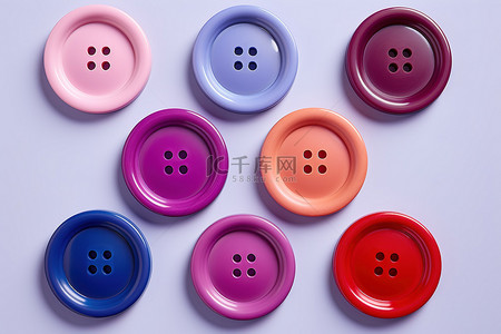 六个彩色塑料按钮板排列在粉色顶部