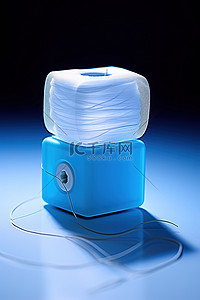 头脑线团背景图片_一个电动纸巾盒旁边放着一团白色的线