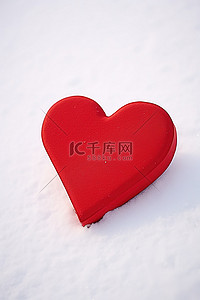 寒冷的白雪上的一个红色心形盒子