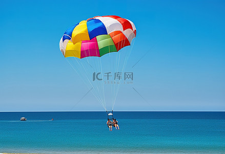 滑翔伞手绘背景图片_两个人在海滩玩滑翔伞
