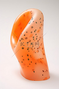 足低穴位图背景图片_白色表面上放置着一个大的橙色塑料物体