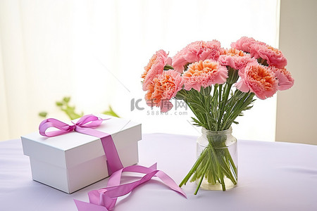 盒子粉色背景图片_粉色康乃馨和旁边的一个白色盒子