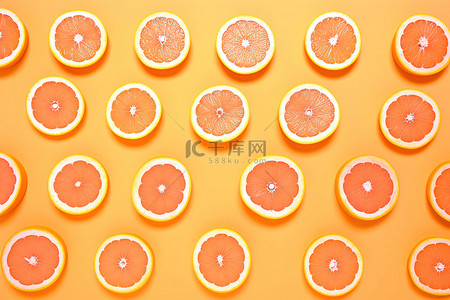 粉红色背景上排列的一排橙子和橙子片