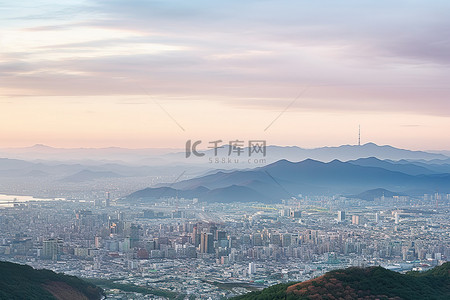国学达人背景图片_从高山上看，前景中有山的城市