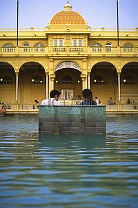 热背景图片_两个人坐在布达佩斯布达佩斯国家游泳池的热水中