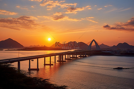 都市大桥背景图片_太阳落在一座桥上，有 koh io 和一座山