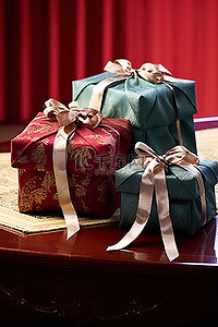 木桌上的两个礼品盒，上面有红丝带
