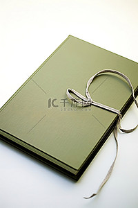 绿色学习学习背景图片_一本绿色的硬皮书，上面绑着一根绳子