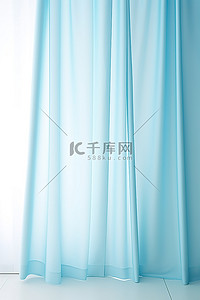 蓝色清爽背景图片_旁边挂着浅蓝色布料的窗帘